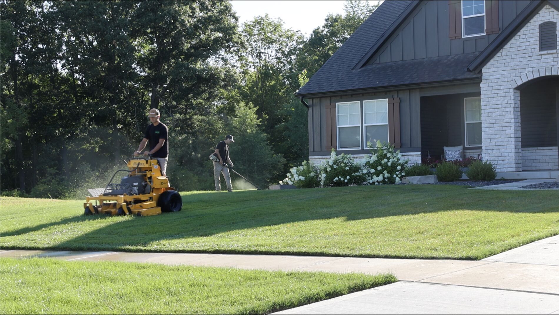 Overtime Lawncare crew mowing and trimming a front lawn